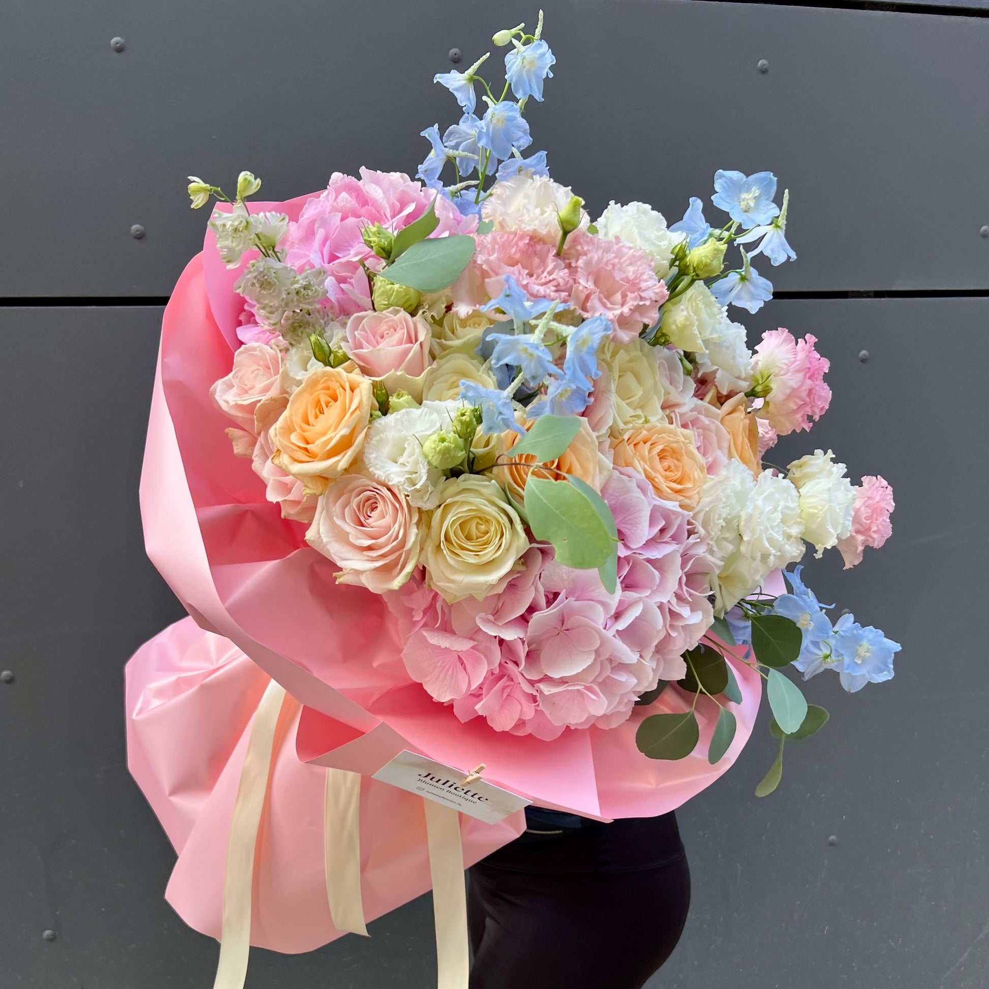 Bouquet of pastel flowers wrapped in pink paper