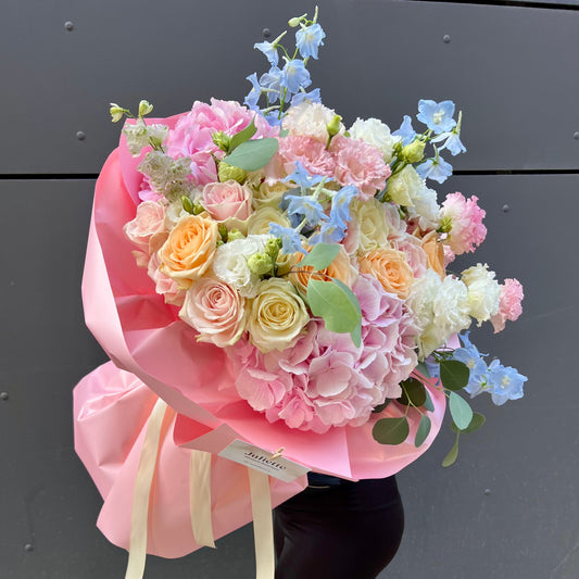 Bouquet of pastel flowers wrapped in pink paper